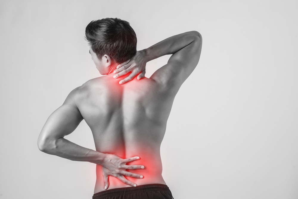 Close up of man rubbing his painful back isolated on white backg