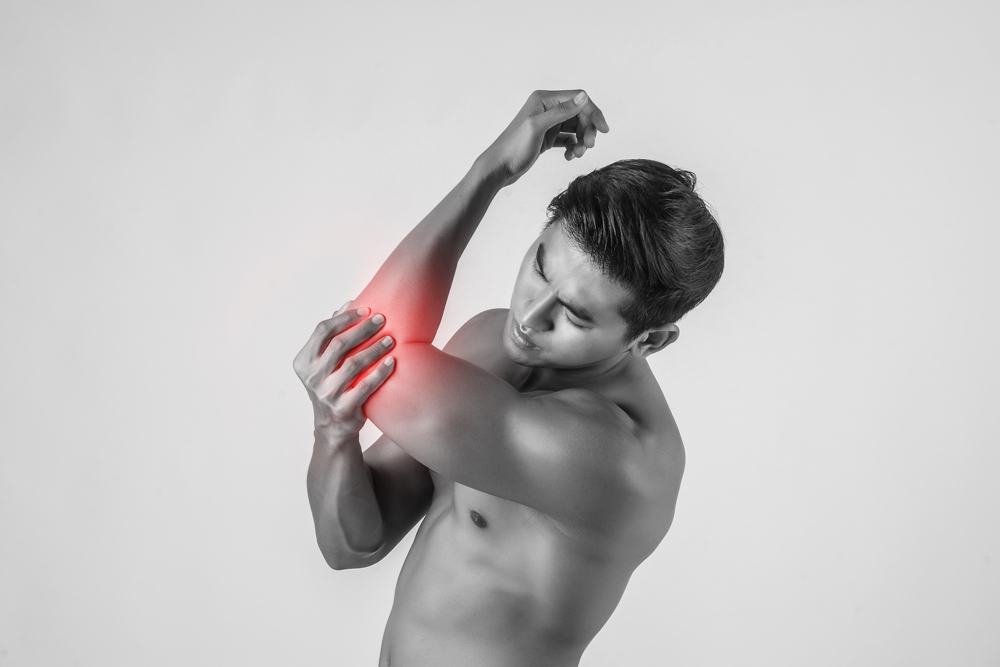 Portrait of a muscle man having elbow pain isolated on white bac